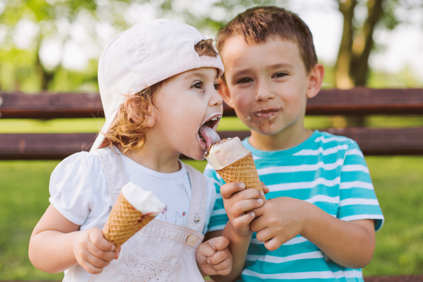 smiling brother and sister licking ice cream