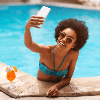 a woman takes a picture by the pool