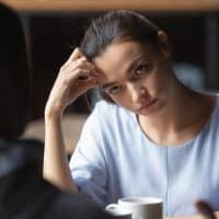 woman looking at man while sitting in cafe