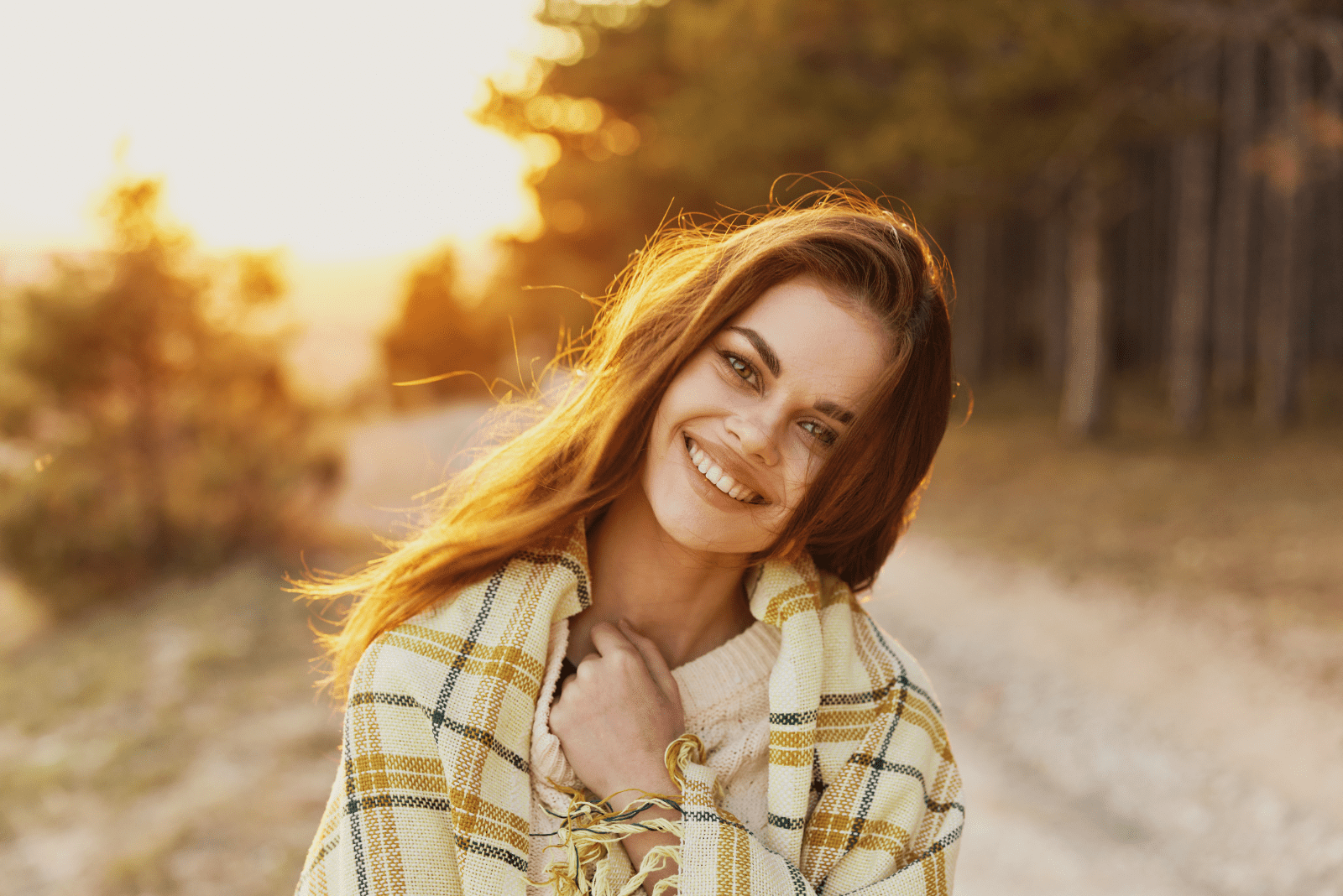 a beautiful woman wrapped in a blanket is standing on the street