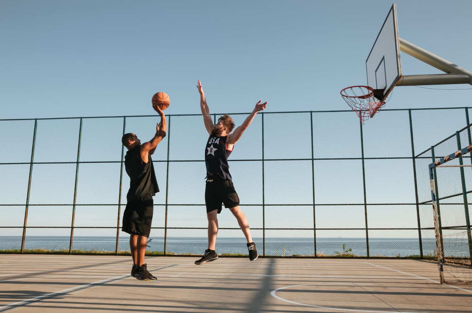 dos hombres jugando al baloncesto