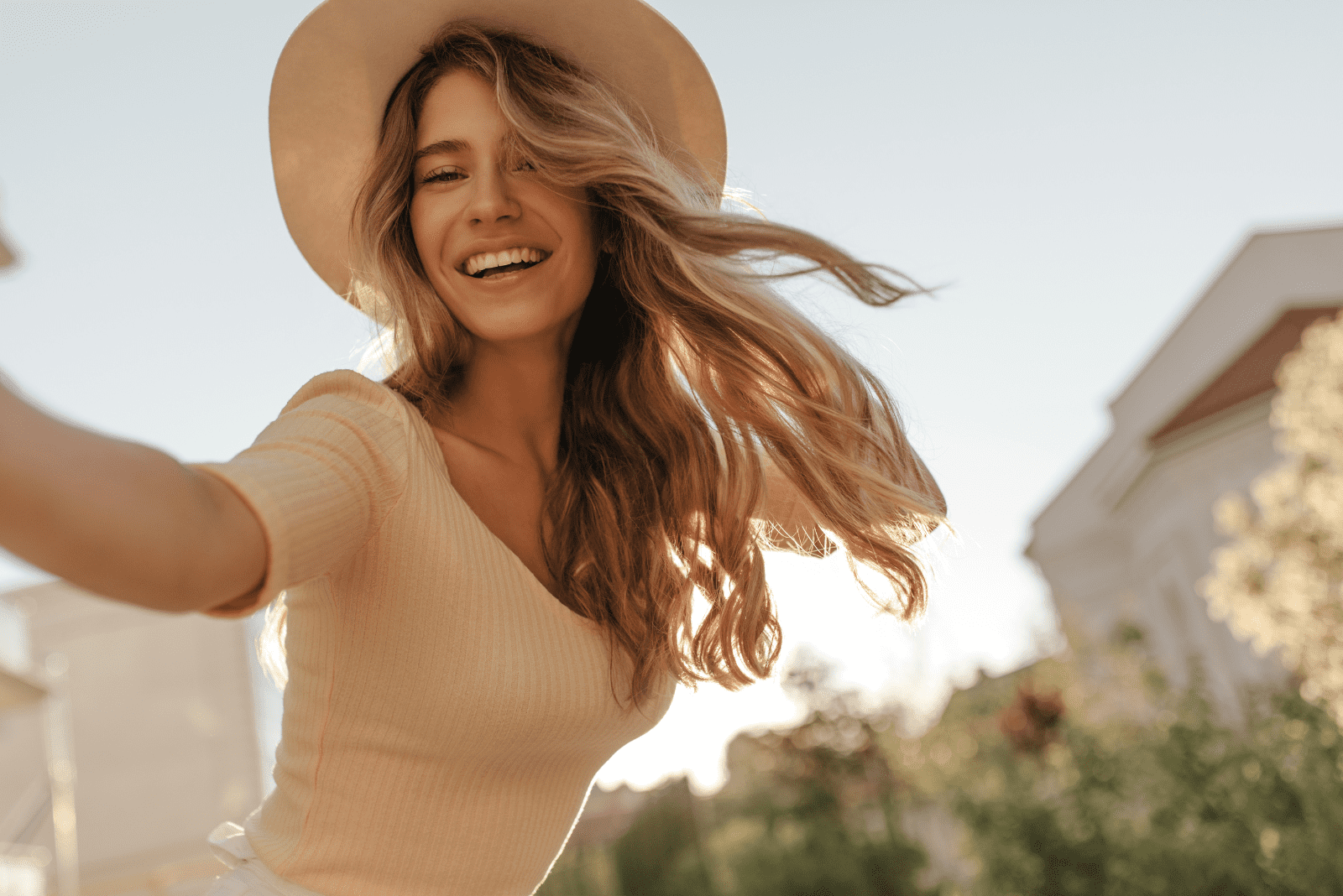 una mujer sonriente con el pelo largo y castaño está haciendo una foto