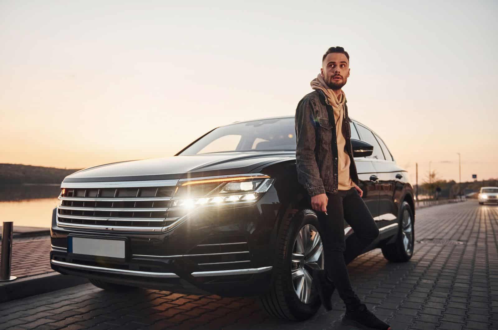 man leaning over hood of a car