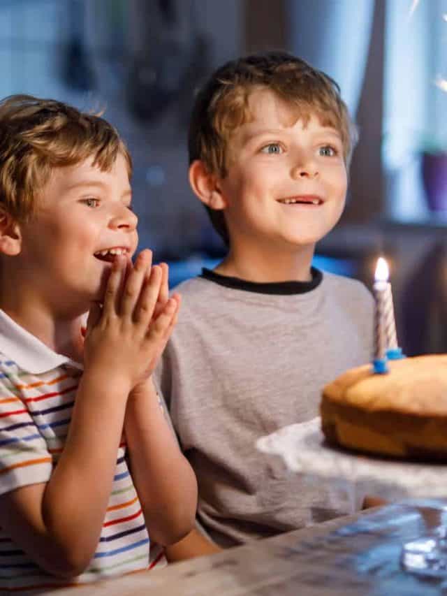 two boys blowing out candles on cake