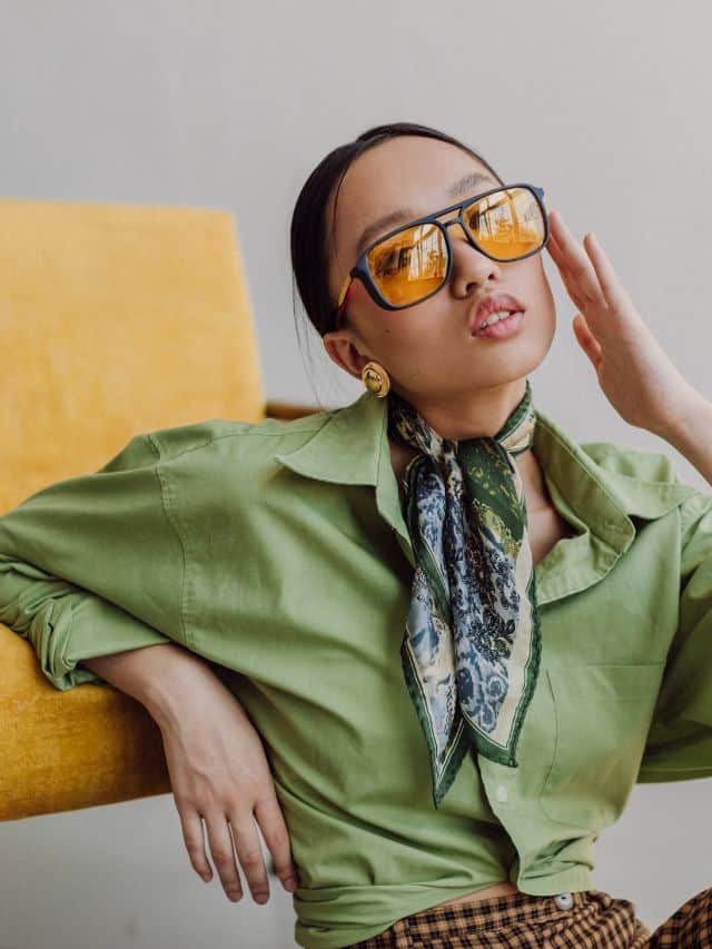 girl in the green shirt and orange sunglasses sitting