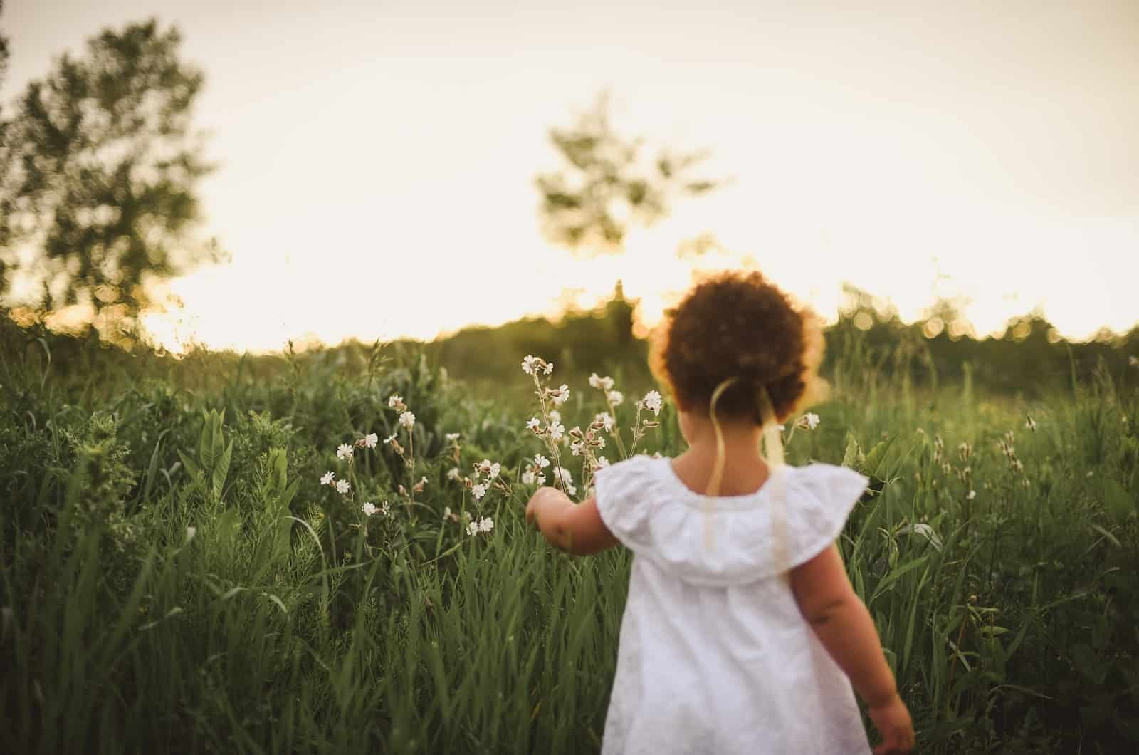 little girl standing in a field