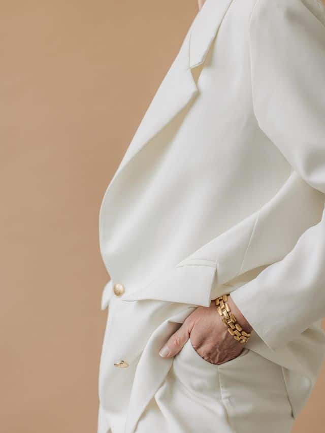 woman in a white suit with gold bracelet