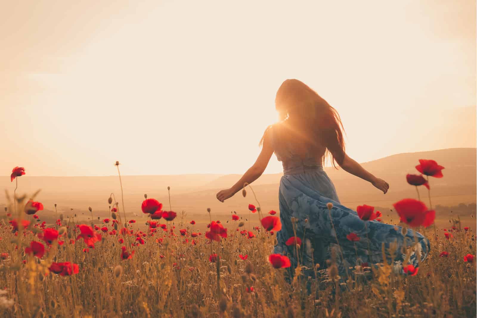 woman in field of flowers in sunset
