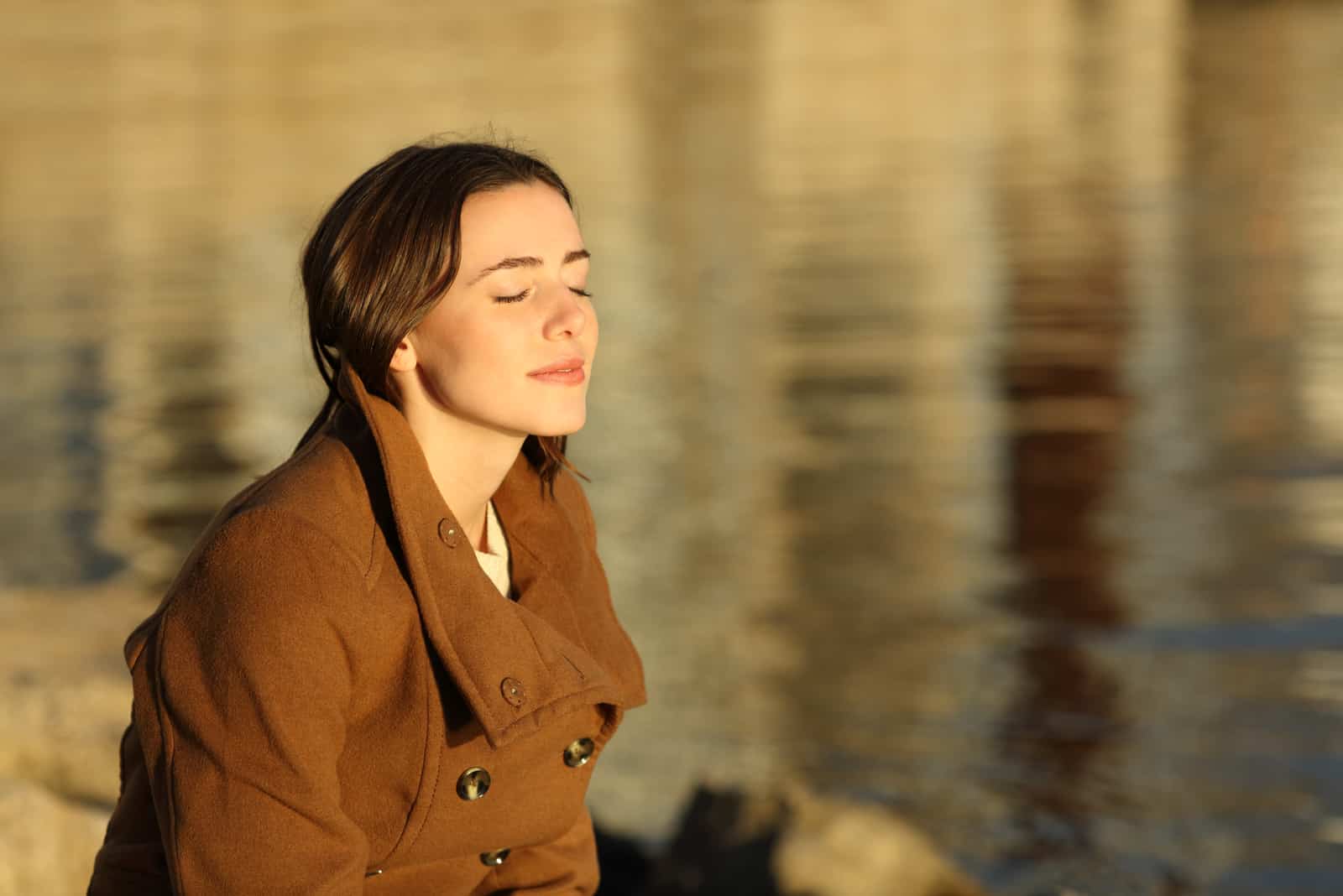 woman sitting by lake