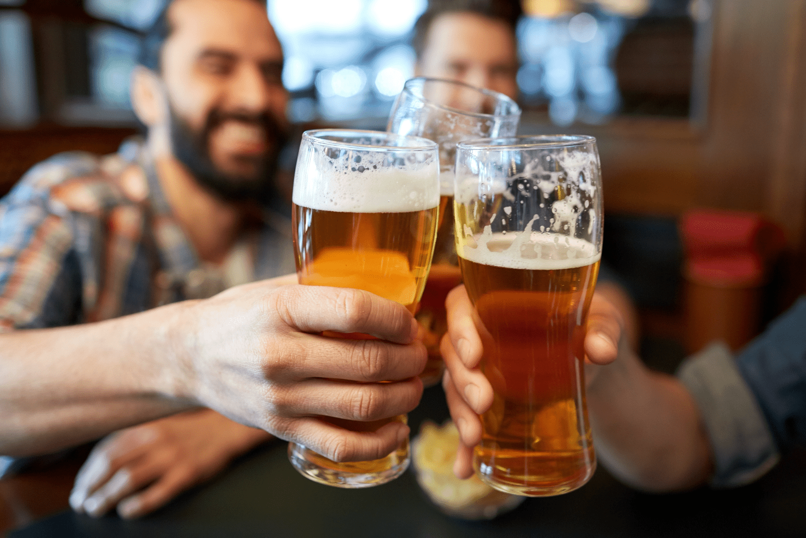 hombres sonrientes brindan con cerveza