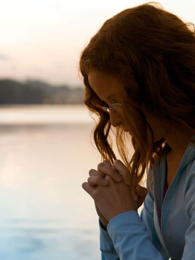 a girl in a blue shirt with brown hair pray