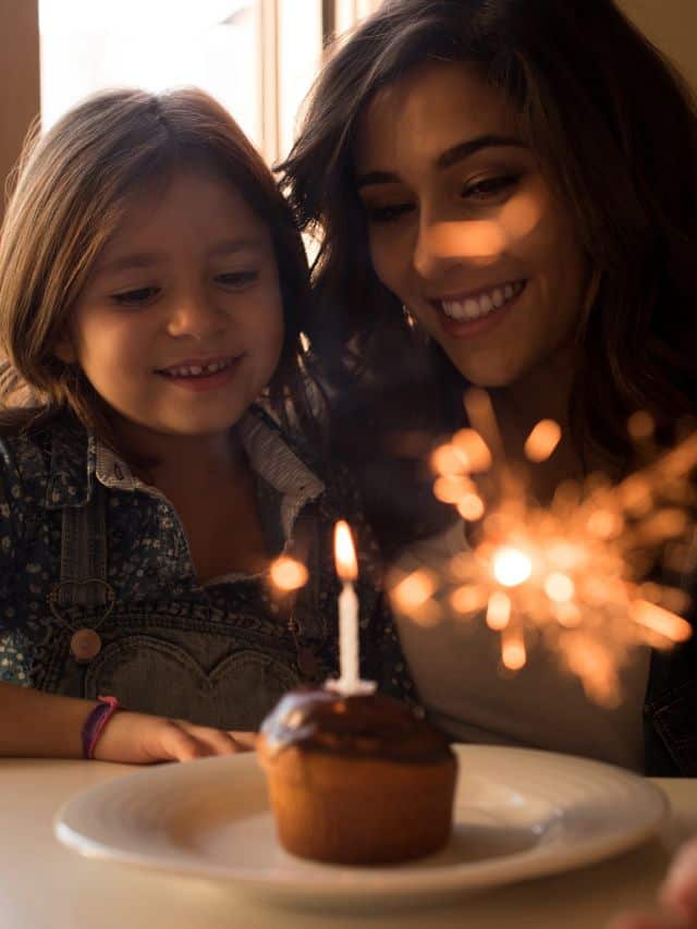 a girl with a brown hair and woman with a black hair smiling in front of cupcake