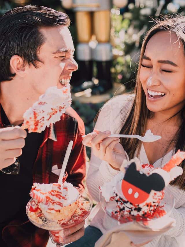 couple with brown hair smiling and eating cake