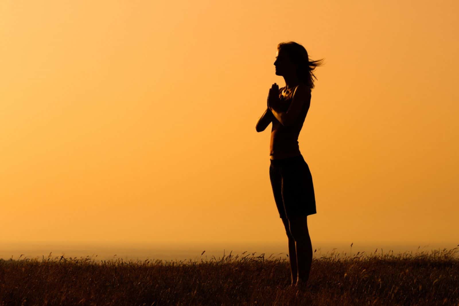 Silhouette of a woman meditating