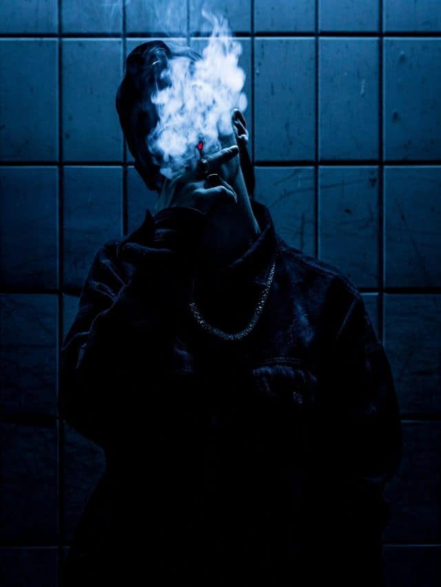 man holding a cigarette and smoking