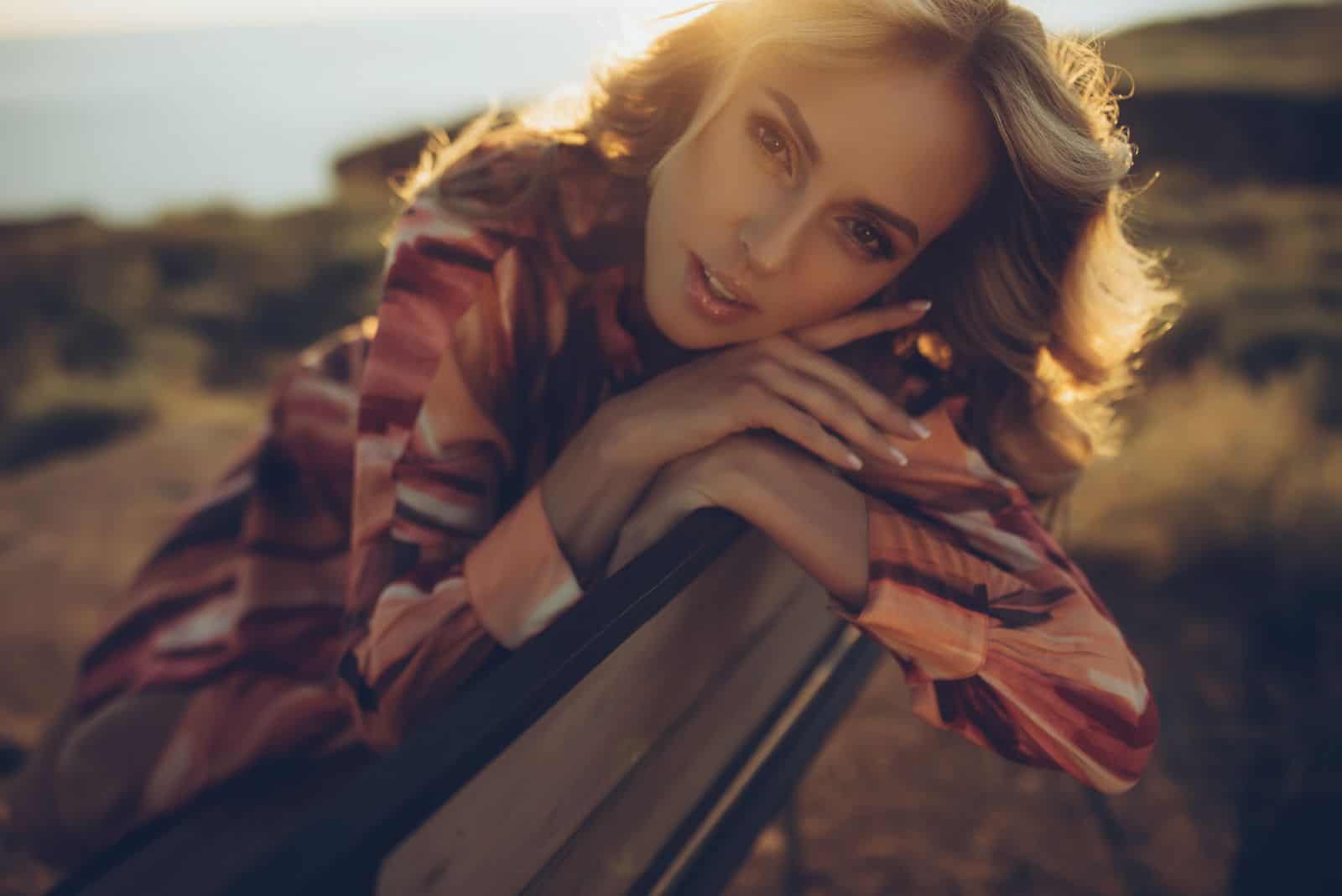 a beautiful girl is sitting on a bench