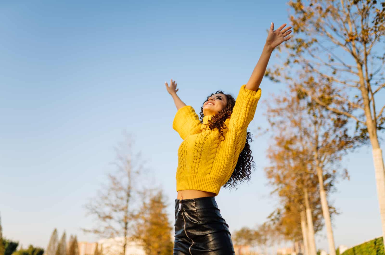 happy girl with her arms up in park