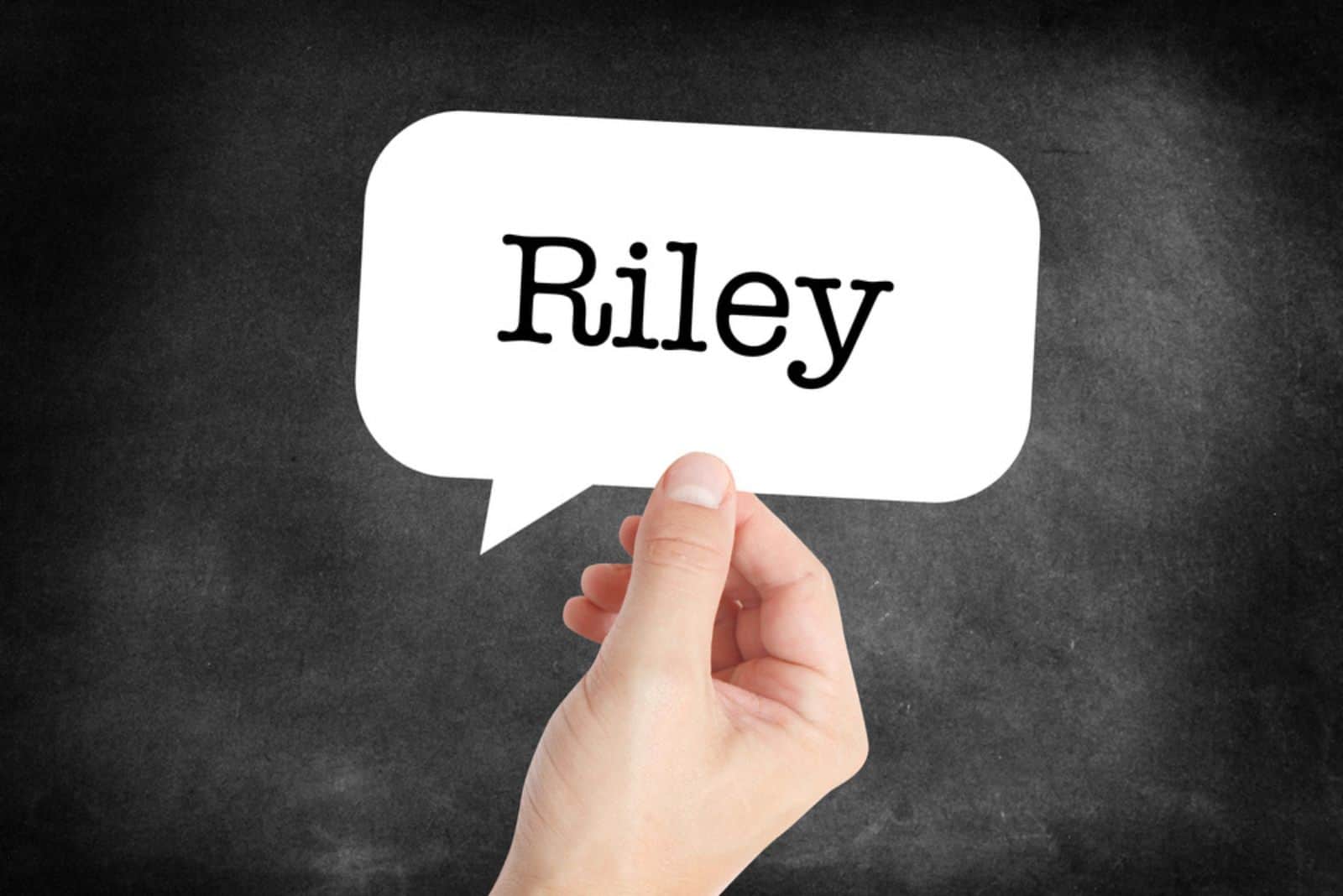 mano sosteniendo un papel con el nombre de riley escrito