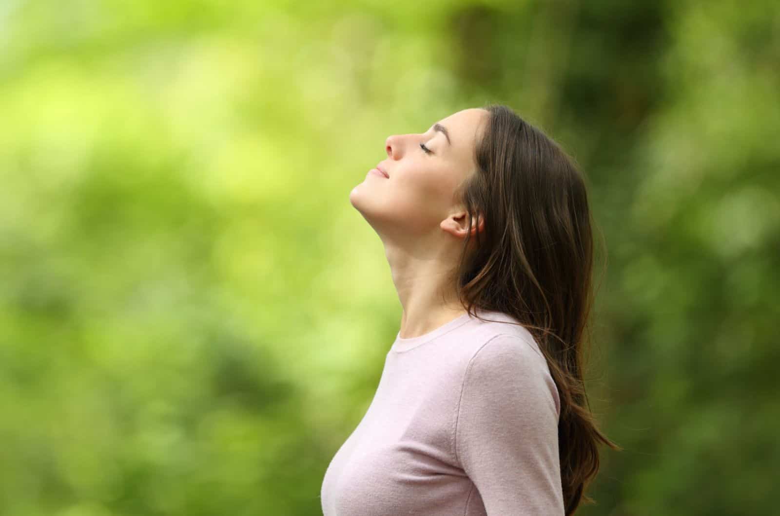 spiritual woman doing breathing exercises and affirmations in nature