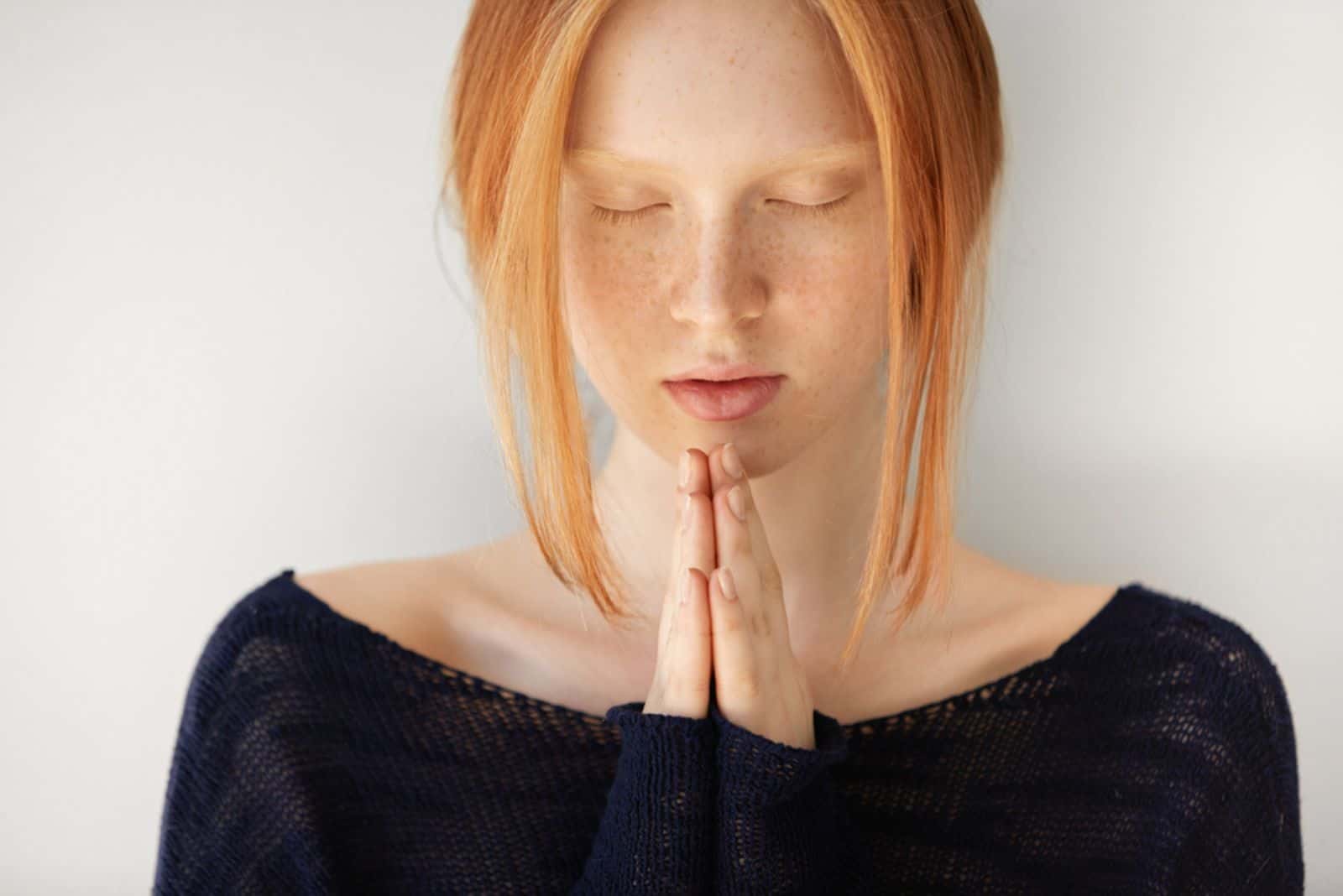 young woman with red hair praying