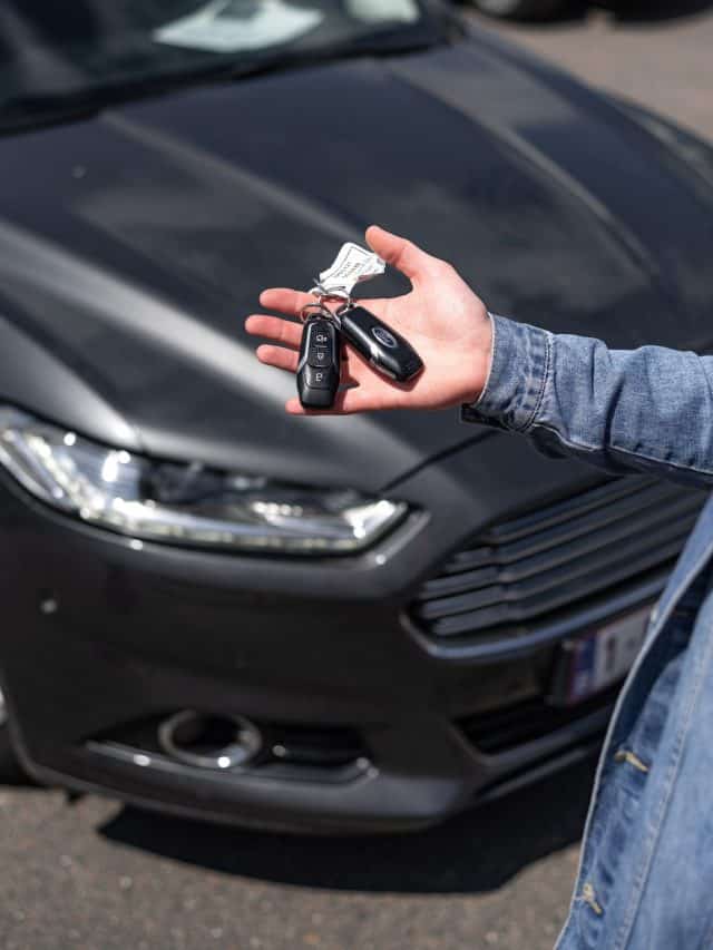 man holding keys for a black car