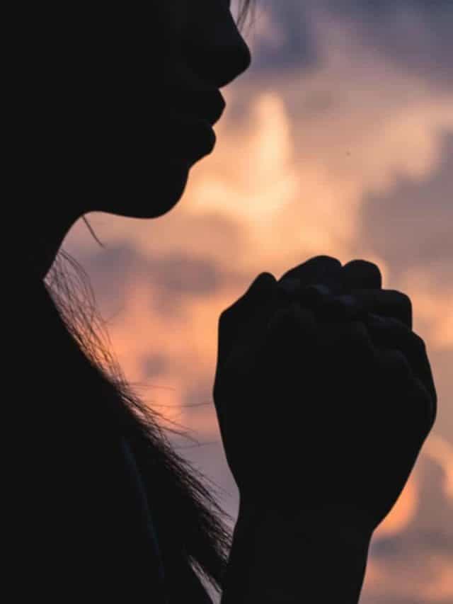 Silhouette off young woman praying for God's blessings