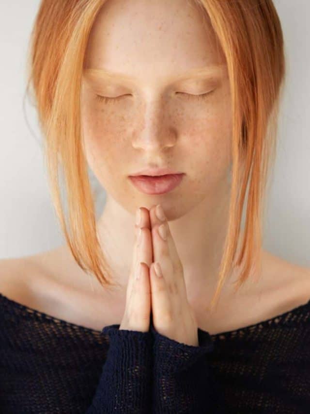 young woman with red hair praying