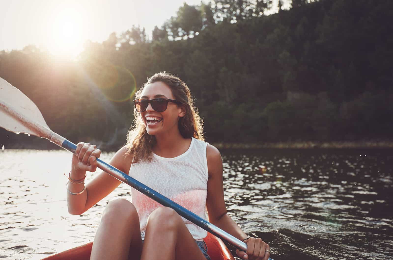 happy young woman on boat on lake
