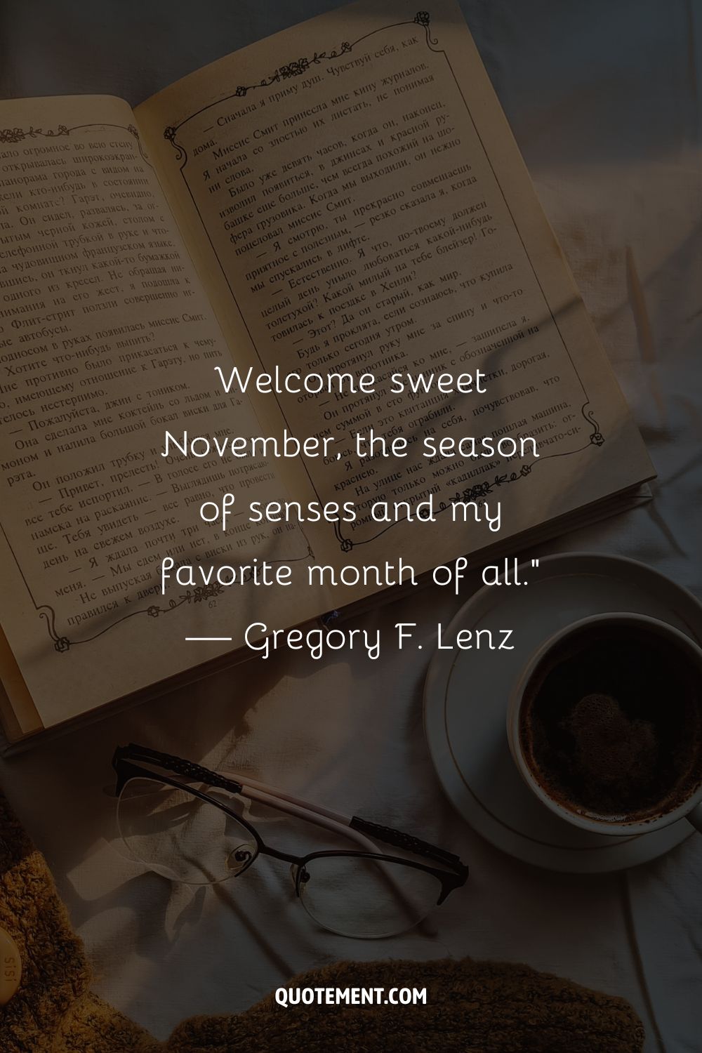 Image of an open book next to a coffee cup representing the best November quote.

