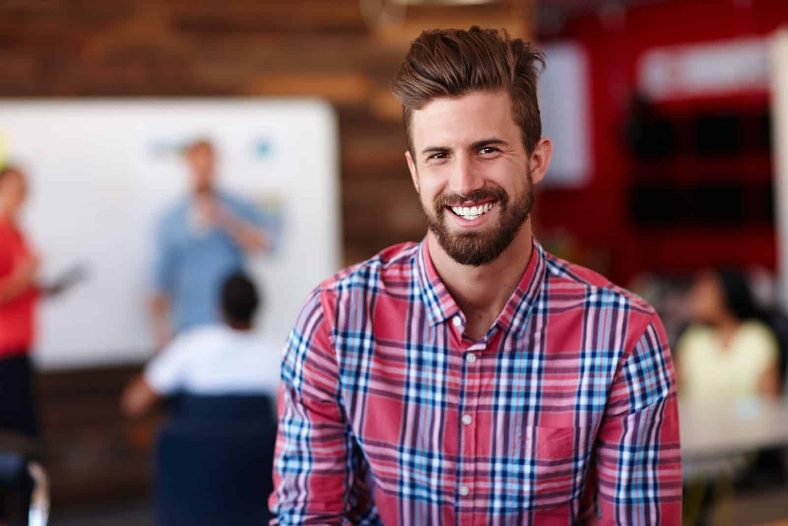 a smiling man in a checkered shirt