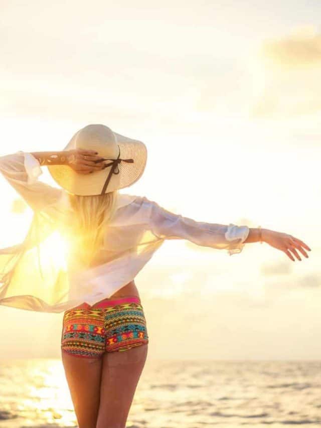 Woman in swiming suit posing on the beach at sunset