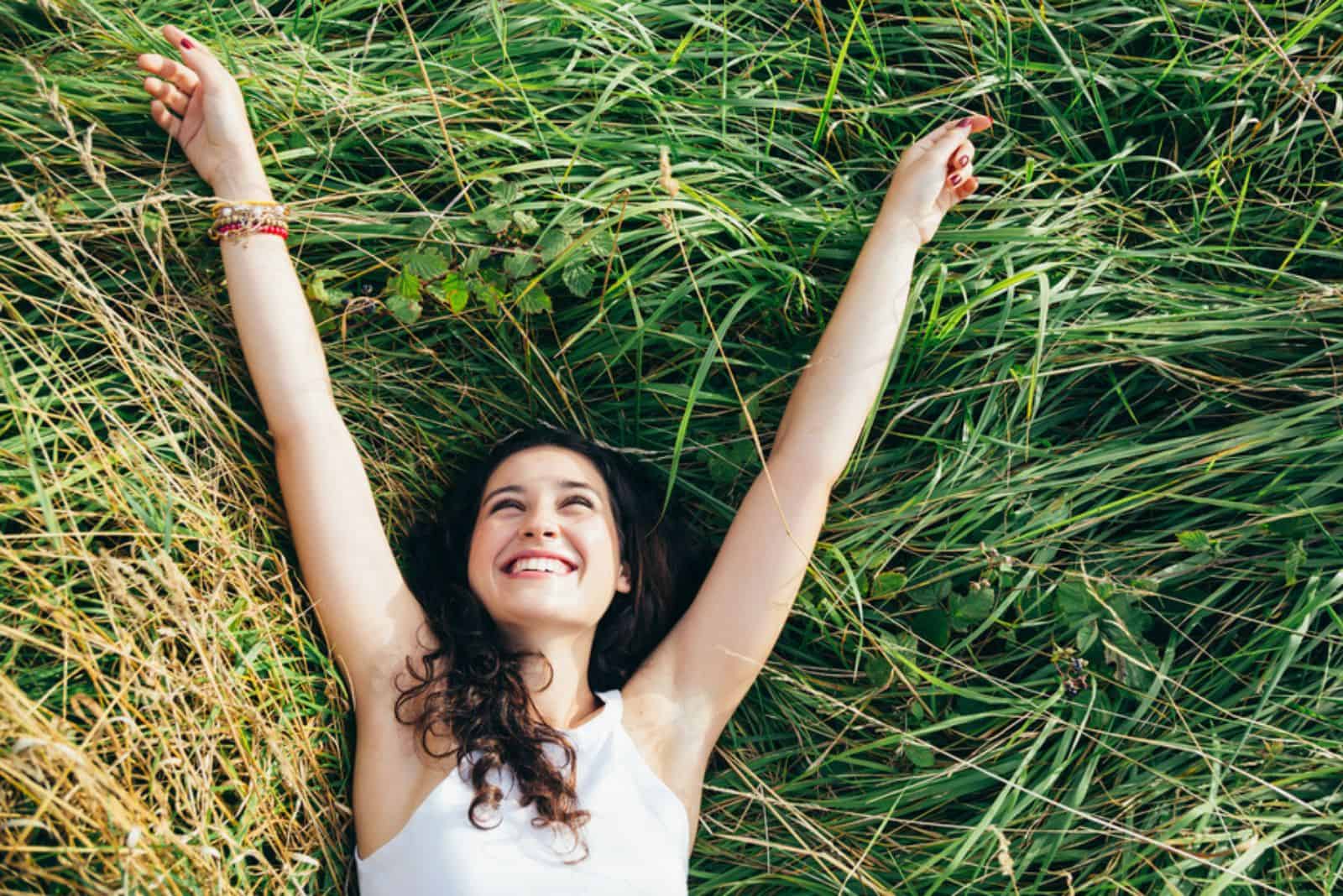  woman laughing in a bed of grass 