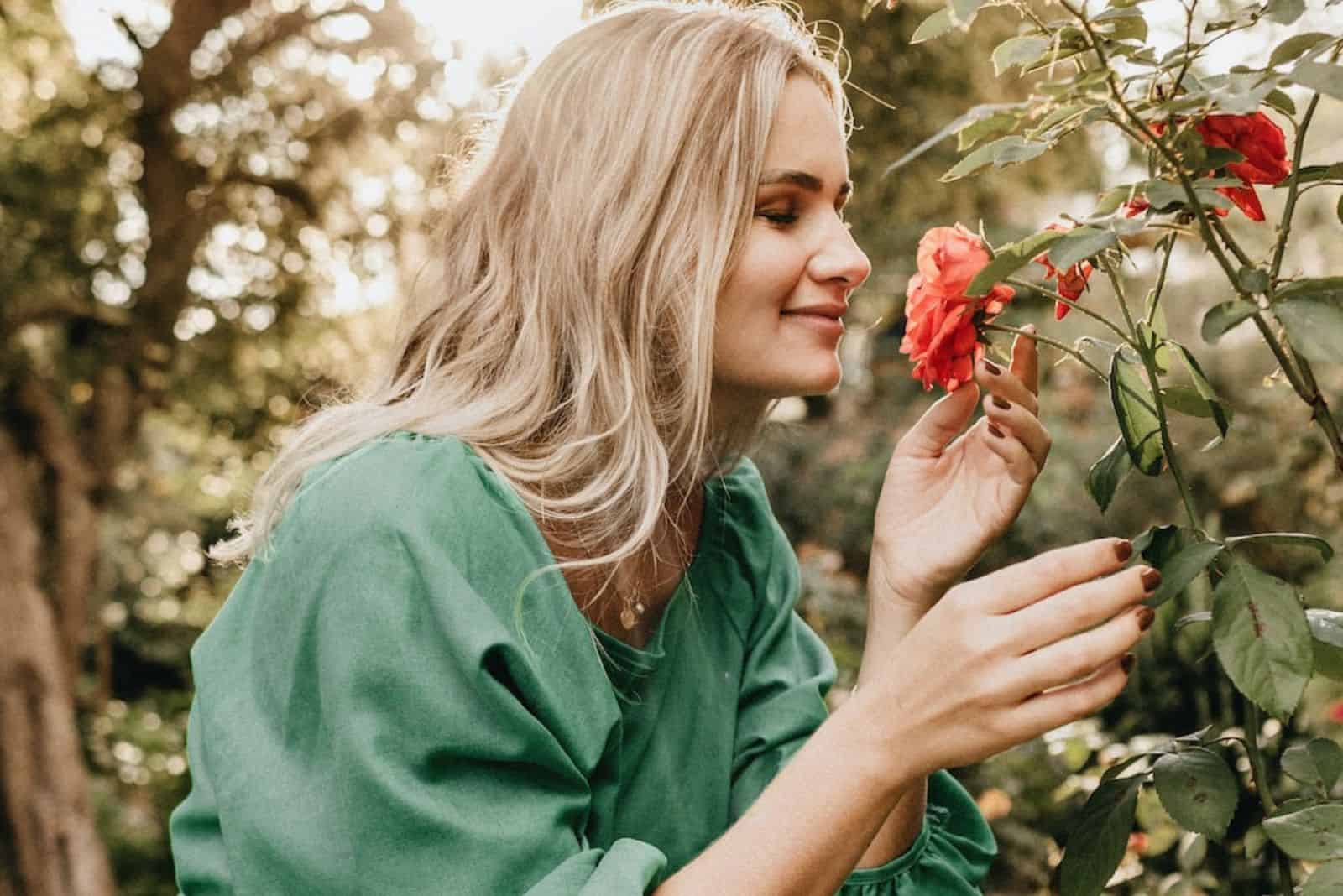 a beautiful woman smells a rose