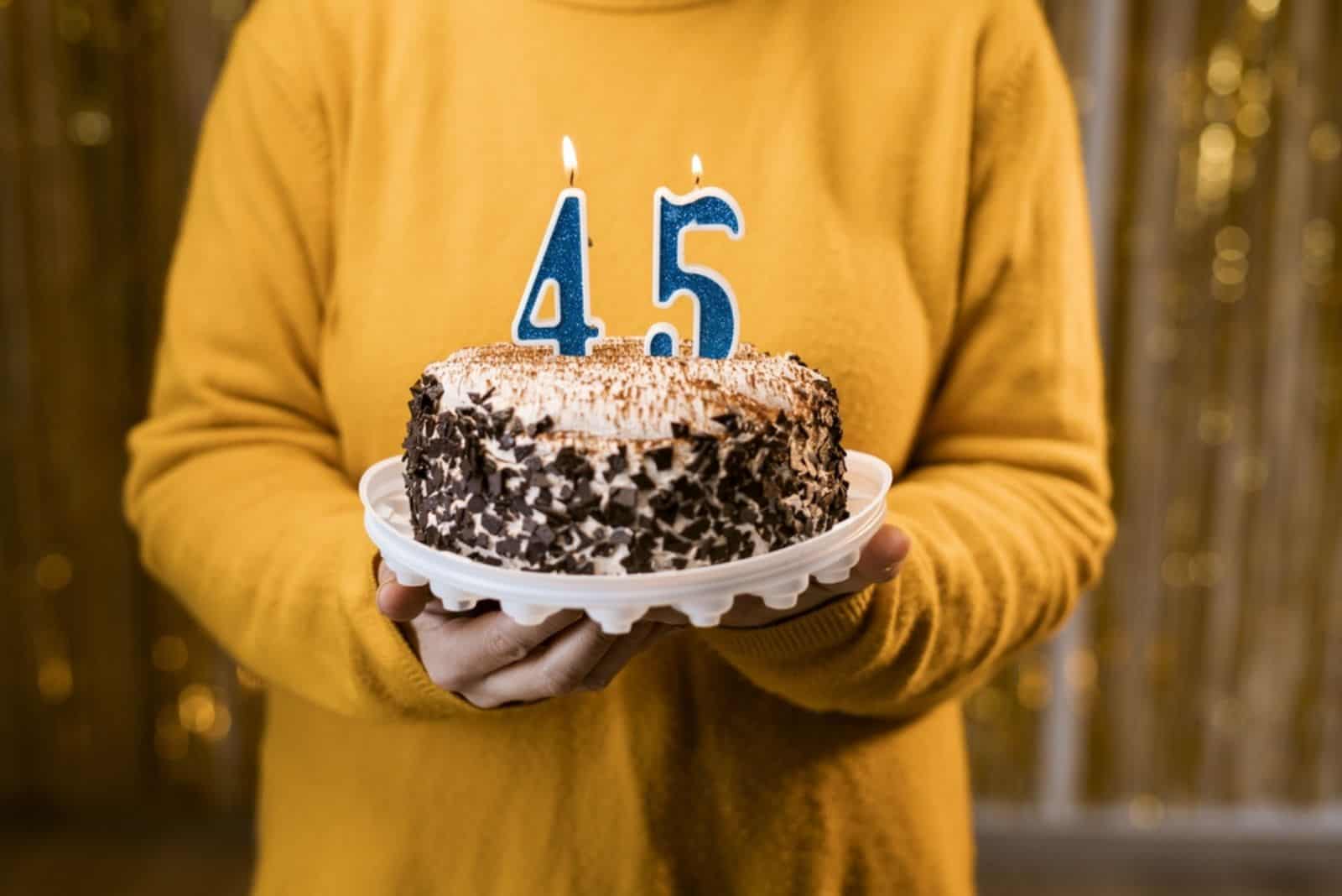 a man holds a cake in his hand