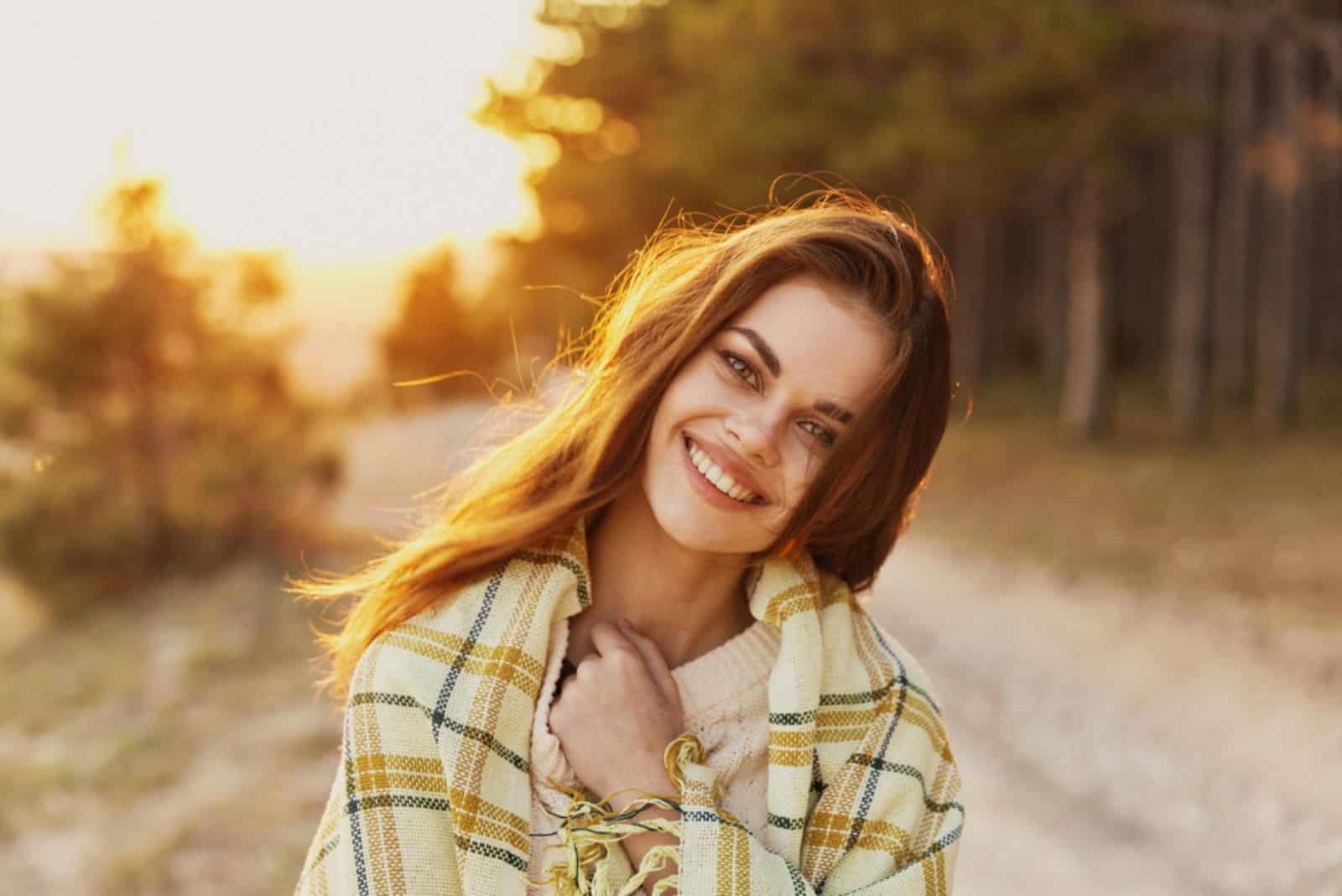 Happy woman with bread on her shoulders laughs