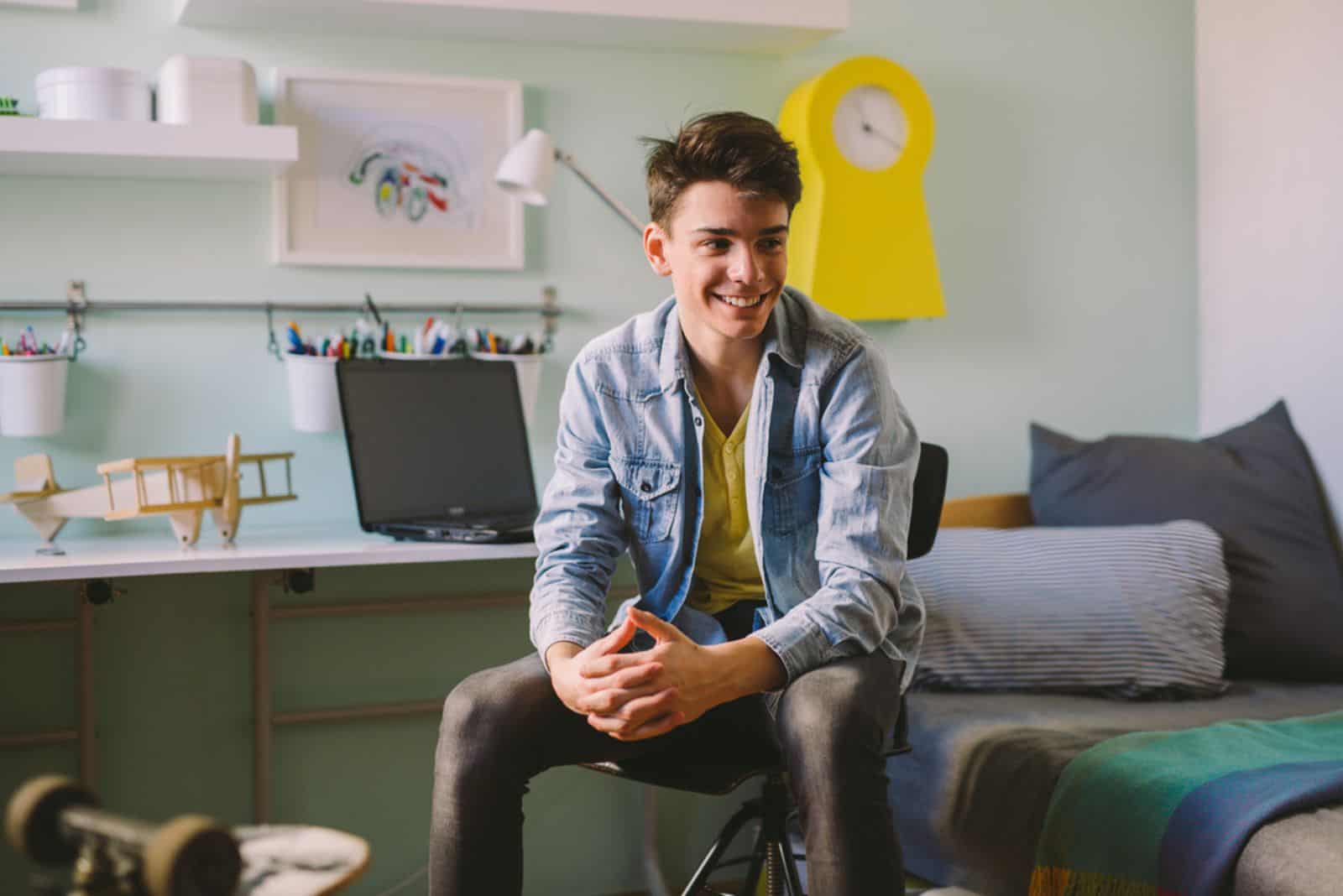 Teenage boy sitting in his room
