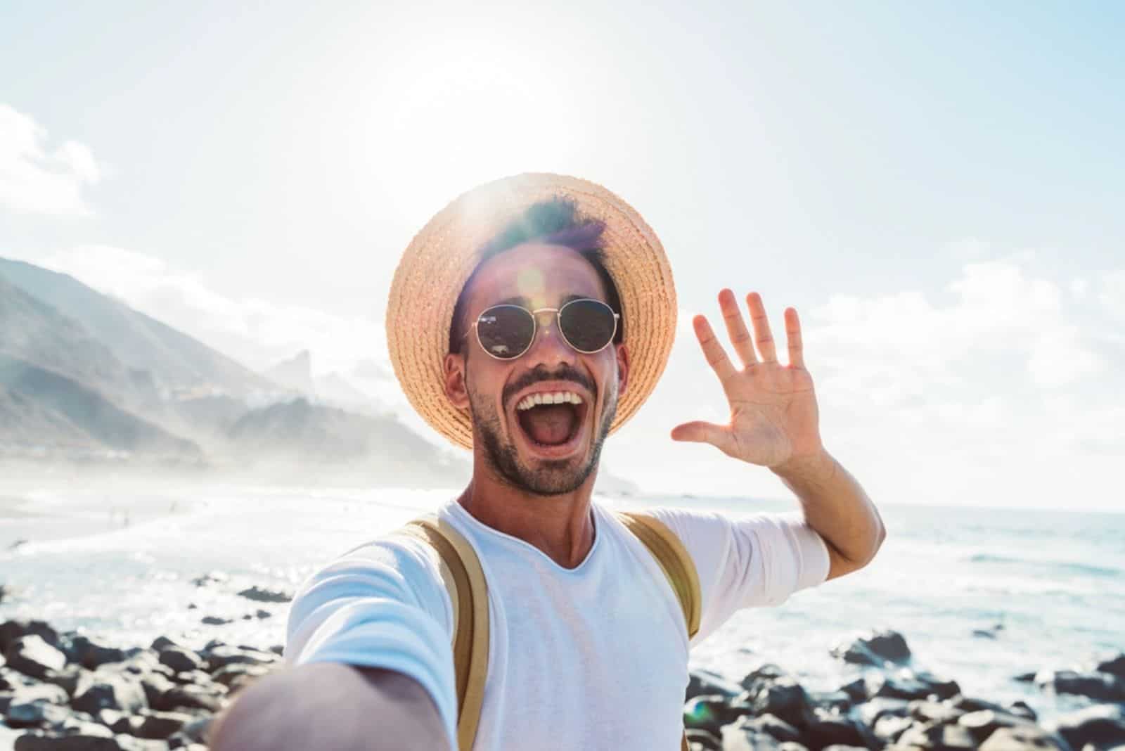 Young man with backpack taking selfie