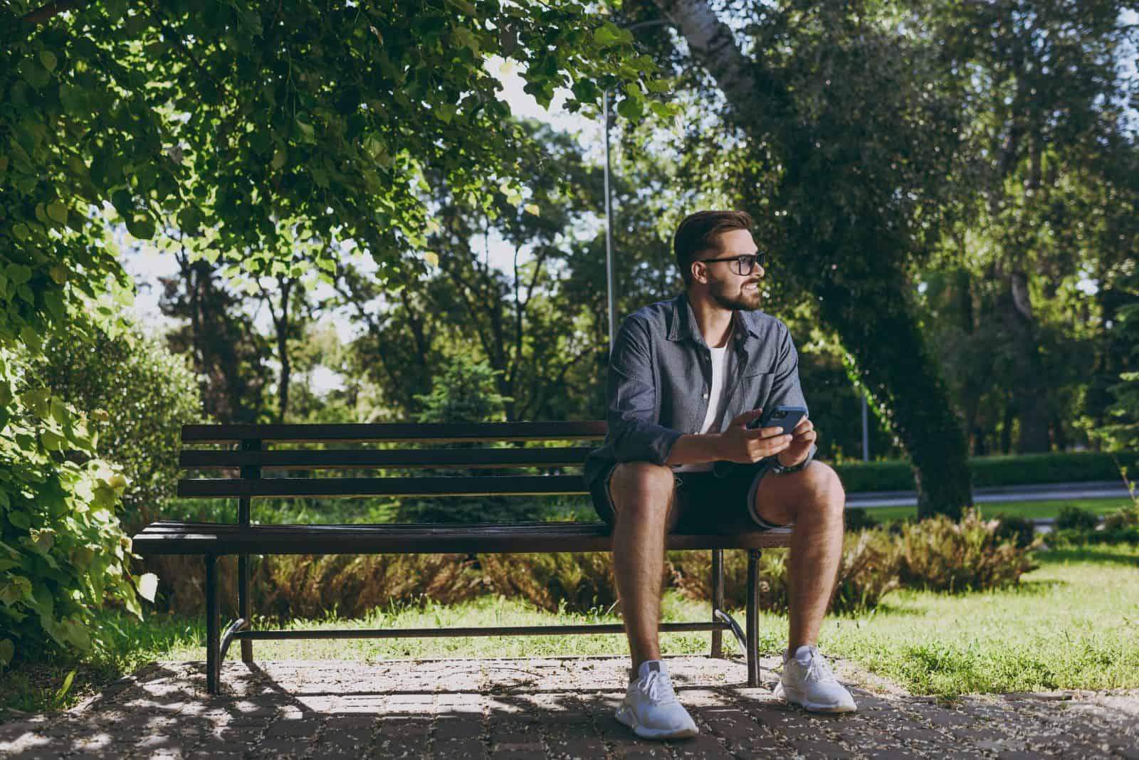 a man is sitting on a park bench