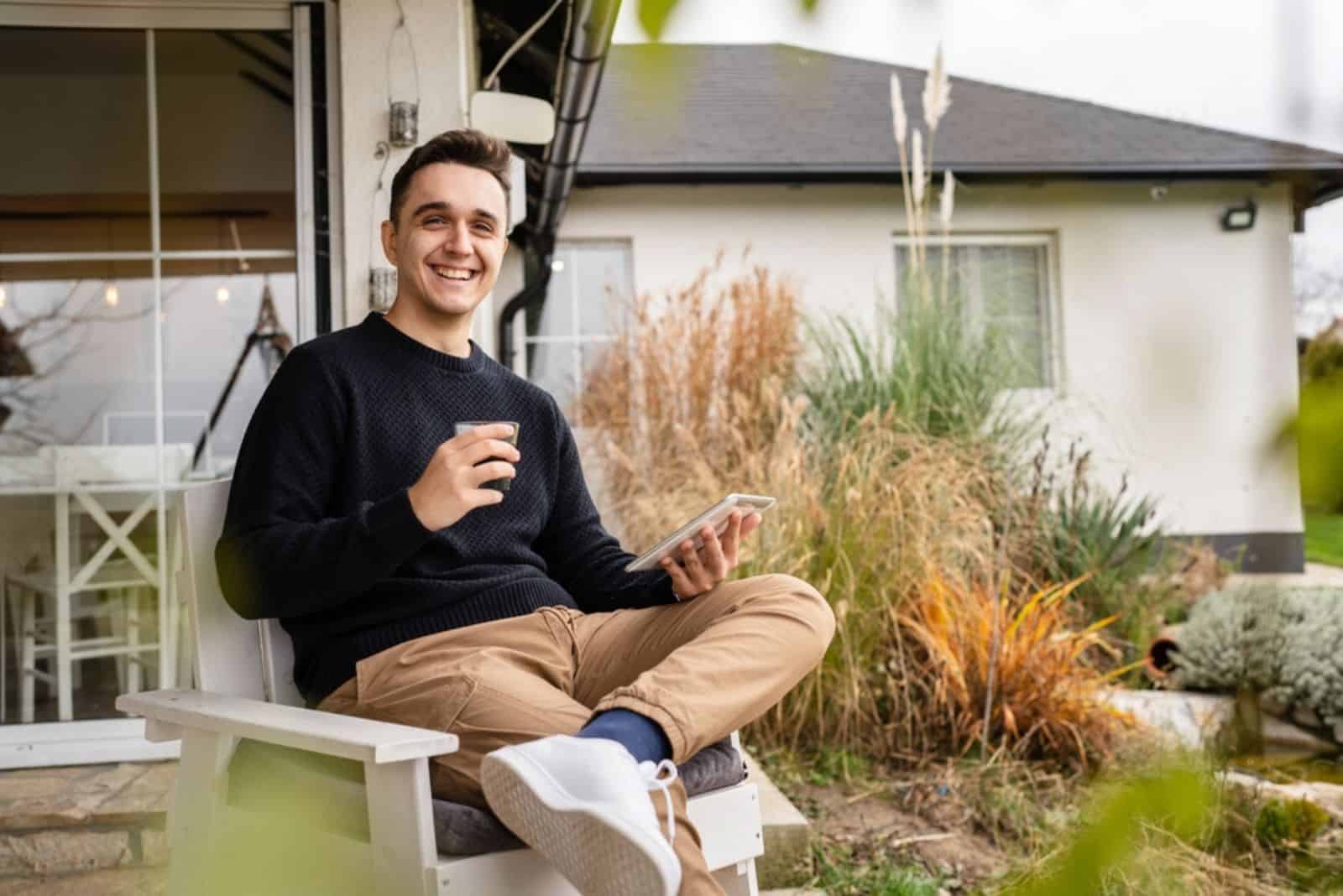 a smiling man is sitting on a chair