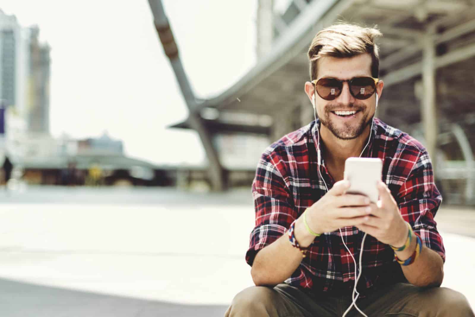 hombre sonriente con gafas y auriculares en los oídos