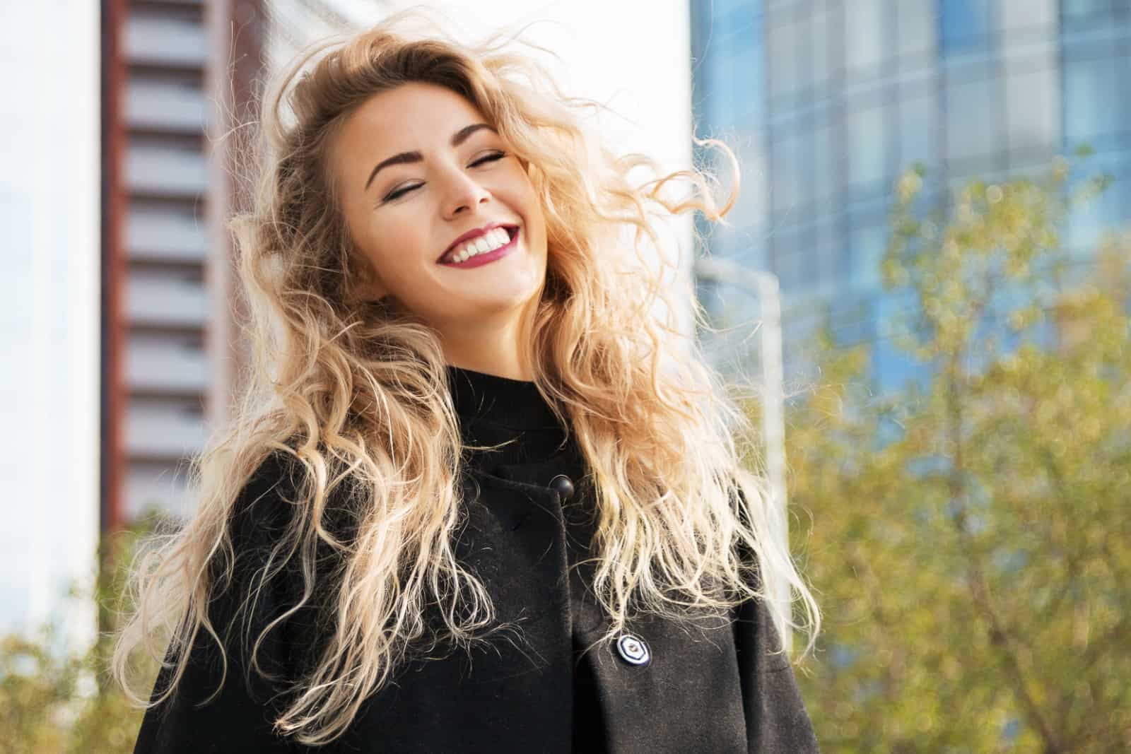 Outdoors lifestyle fashion portrait of happy stunning blonde girl