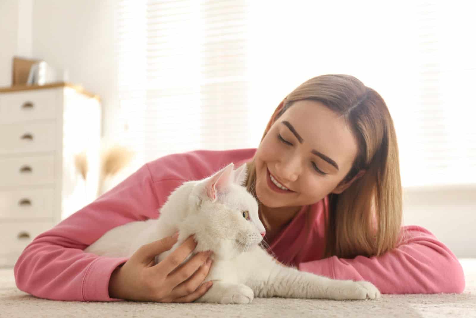 Young woman with her beautiful white cat at home