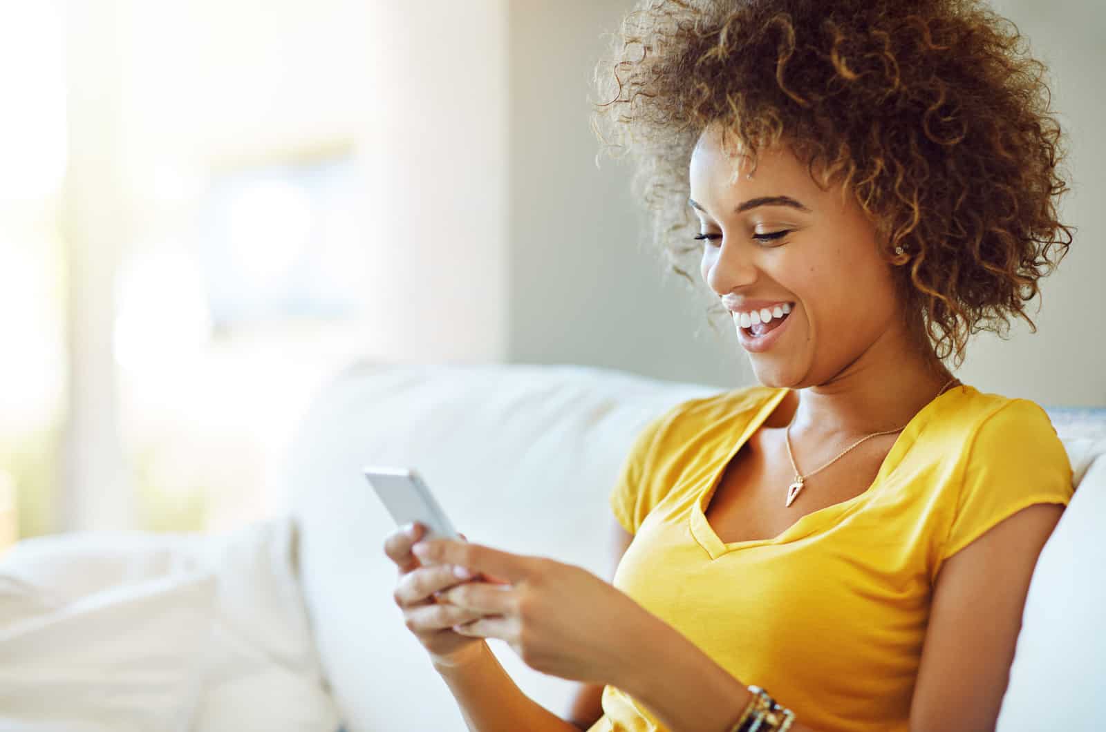 mujer feliz riendo y enviando mensajes de texto