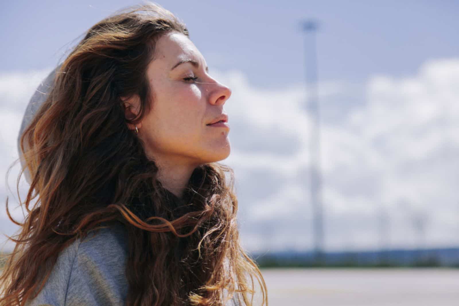 mujer joven respirando profundamente al aire libre