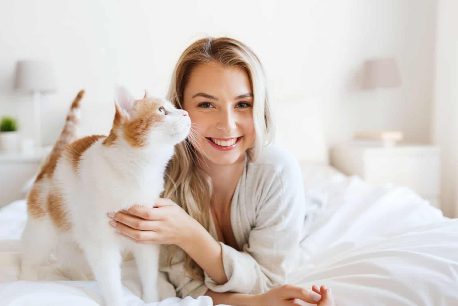 mujer joven con gato en la cama