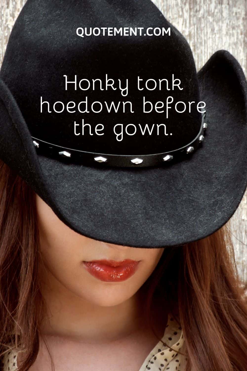 a girl looking down wearing a silky black cowgirl hat
