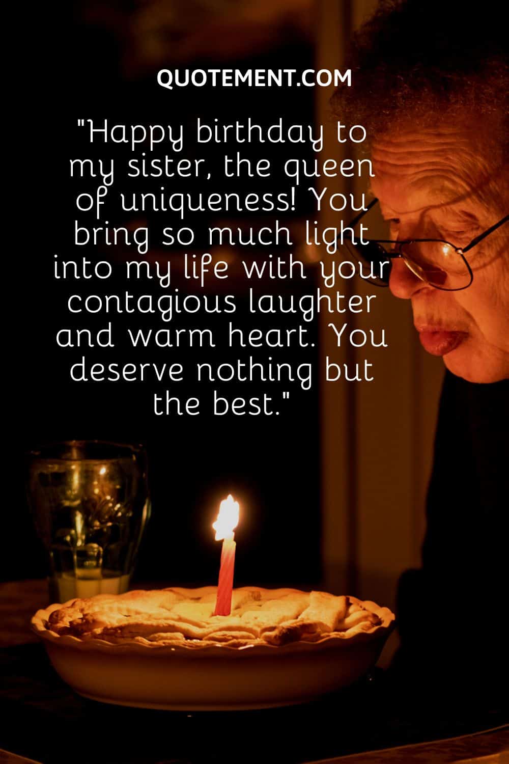 an older woman blowing candle on a pie
