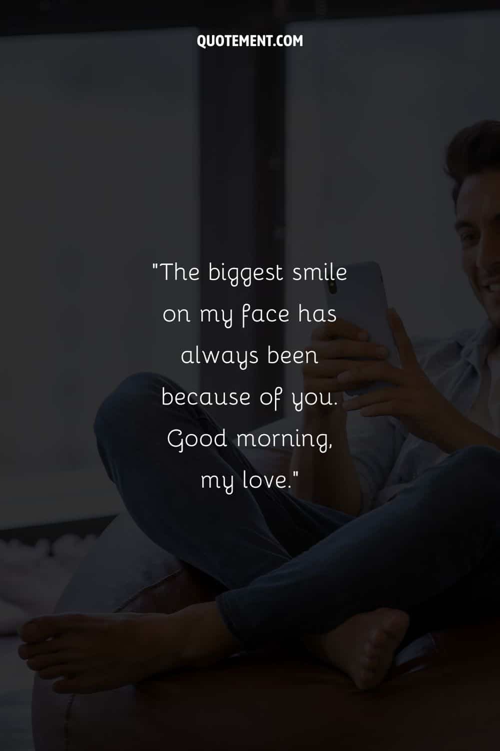 a young man sitting captivated by his phone's screen representing a cute good morning text