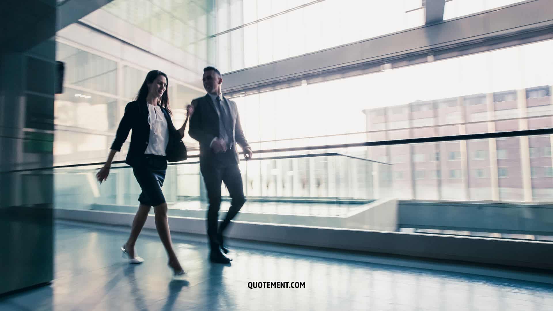 man and woman walking in a building