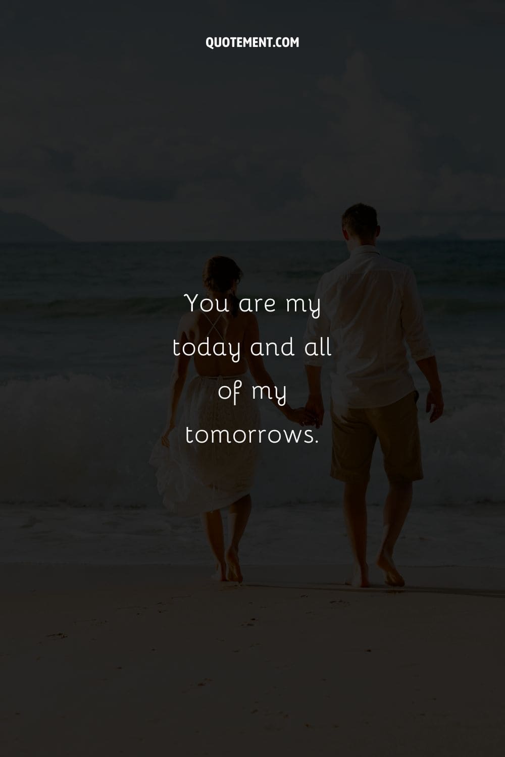 Couple's bond shines as they walk on beach, hands clasped.